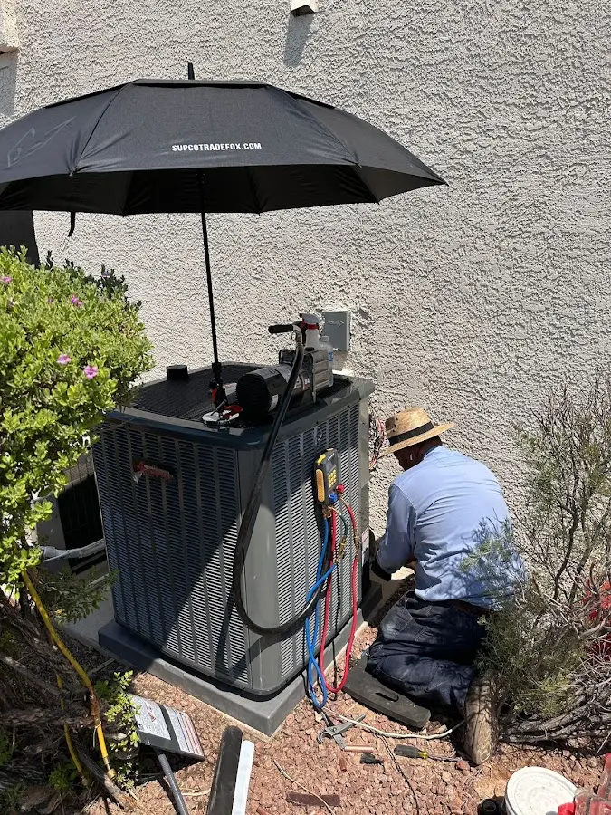 HVAC technician performing outdoor AC maintenance in Summit View