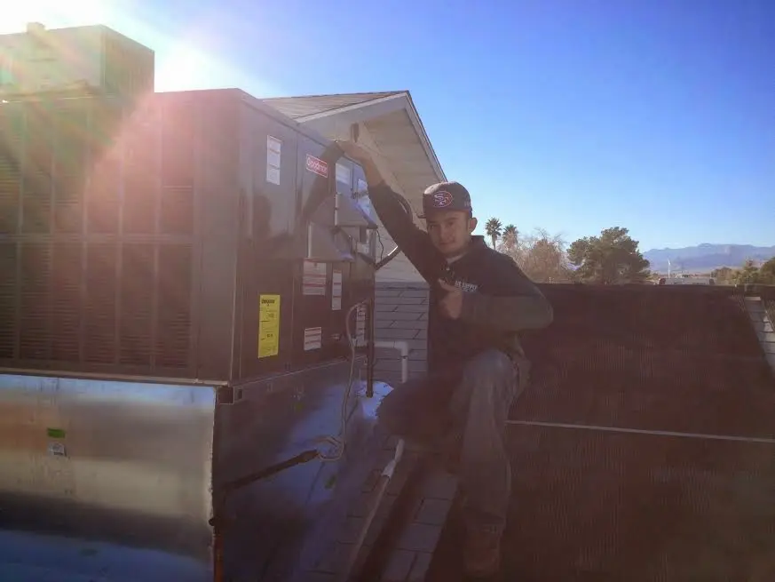 HVAC technician performing AC Tune-Up on a rooftop unit in Summit View